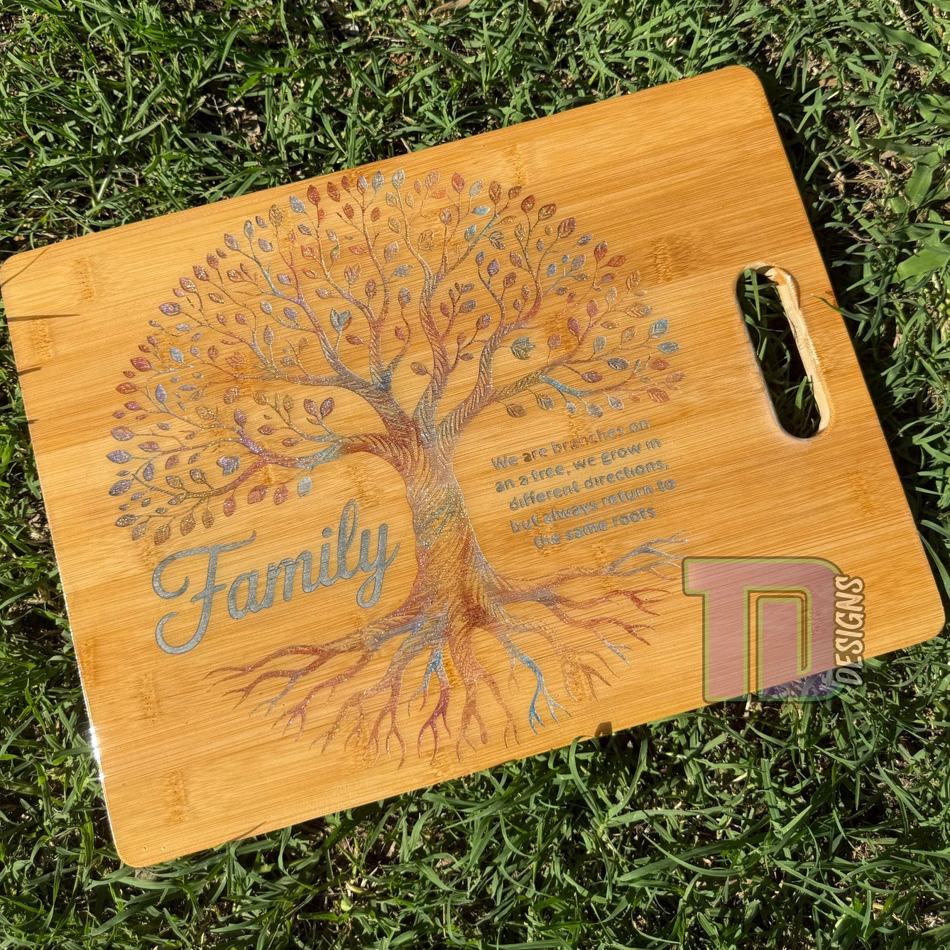 Wooden cutting board with family tree design on grass